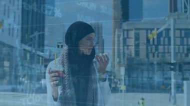 Animation of financial data processing over woman in hijab talking on smartphone on the street. Global finance and business technology concept