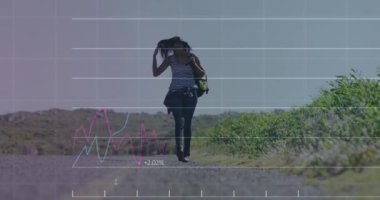 Animation of financial data processing over biracial woman walking on street. Global business, finances and digital interface concept digitally generated video.