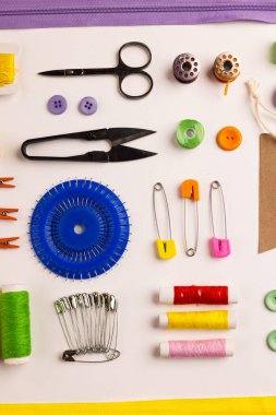 Image of sewing materials with scissors, buttons and threads on cream background. Arts and crafts concept.