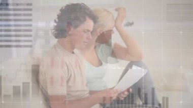 Animation of infographic interface over worried caucasian couple discussing pending bills at home. Digital composite, multiple exposure, together, report, global, home finance and debt concept.