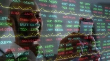 Animation of stock market data processing over biracial businessman using a smartphone. Global economy and business technology concept