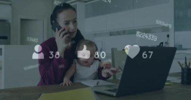 Animation of social media icons over caucasian woman with baby using laptop talking on smartphone. Social media networking technology concept