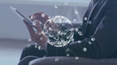 Animation of globe of profile icons over caucasian businessman using digital tablet at office. Global networking and business technology concept