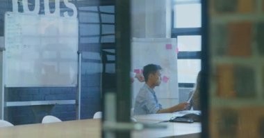 Animation of data processing and cityscape over diverse business people at office. Global business, finances and digital interface concept digitally generated video.