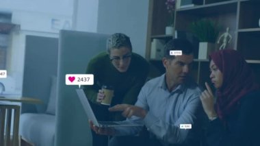Animation of media icons over diverse business people using laptop. Global business and digital interface concept digitally generated video.