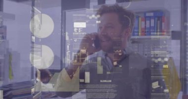 Animation of financial data processing over man using smartphone. Global business, finances, computing and data processing concept digitally generated video.