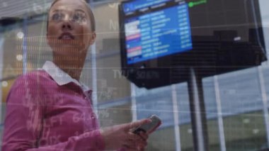 Animation of financial data processing over caucasian businesswoman using smartphone at the airport. Global finance and business technology concept