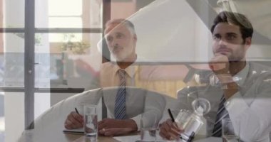 Composite video of close up of wheel of a motorcycle against businesspeople having a meeting. Business technology concept