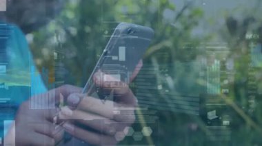 Animation of financial data processing over boy using smartphone. Global business, finances, computing and data processing concept digitally generated video.