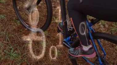 Animation of binary coding and data processing over woman on bike. Global sports, computing and data processing concept digitally generated video.