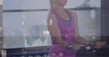 A fit woman lifting dumbbells in a gym in high quality 4k format. Global business communication and data network concept digitally generated video.