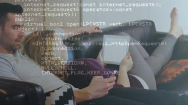 Animation of financial data processing over man and woman using smartphone and tablet. Global business, finances, computing and data processing concept digitally generated video.