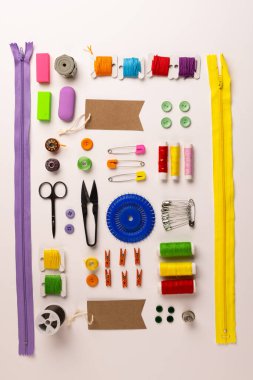 Image of sewing materials with scissors, buttons and threads on cream background. Arts and crafts concept.