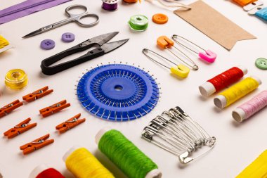 Image of sewing materials with scissors, buttons and threads on cream background. Arts and crafts concept.