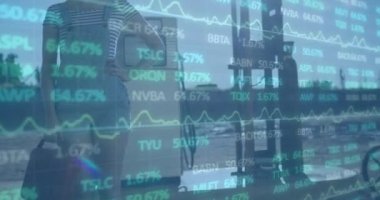 Animation of financial data processing over biracial woman fueling car at gas station. Global finances, transport and sale concept digitally generated video.