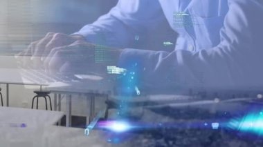 Animation of data processing over mid section of man using laptop against aerial view of cityscape. Computer interface and business technology concept