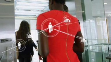 Animation of network of digital icons over rear view of businesspeople entering in a escalator. Global networking and business technology concept