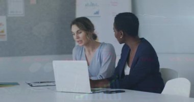 Animation of financial data processing over diverse businesswomen in office. Global business, finance, computing and data processing concept digitally generated video.