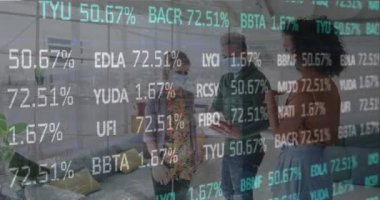 Animation of financial data processing over business people wearing face masks working in office. Global covid 19, computing, finance, business and data processing concept digitally generated video.