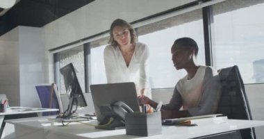 Animation of multiracial coworkers discussing reports over laptop against infographic interface. Digital composite, multiple exposure, globalization, report, finance, teamwork and technology concept.