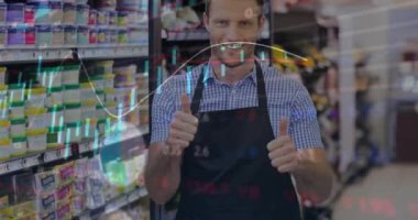 Animation of stock market data processing over caucasian man showing thumbs at grocery store. Global economy and business technology concept
