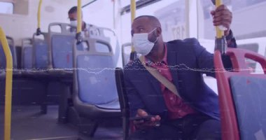 Animation of financial data processing and man in face mask on bus. Covid 19 pandemic, medicine, healthcare, finance, computing and data processing concept digitally generated video.