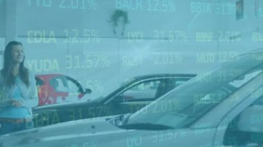 Animation of financial data processing over woman with salesman in car dealer shop. Global business, finance, computing and data processing concept digitally generated video.