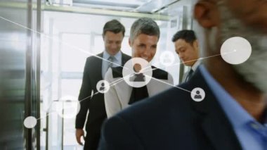 Animation of network of connections with icons over diverse business people working at office. Global business, connections and digital interface concept digitally generated video. 