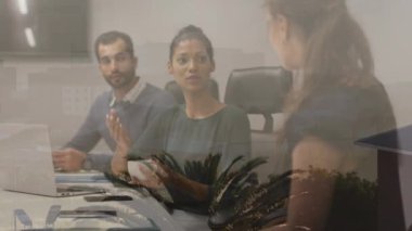 Animation of cityscape over diverse business people in meeting in office. Global business, finance, computing and data processing concept digitally generated video.