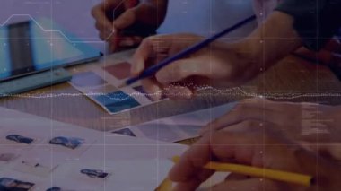 Animation of data processing over mid section of team of designer discussing over color swatches. Business data technology concept