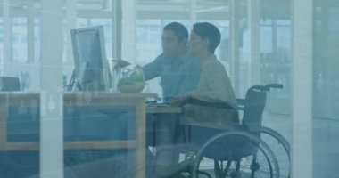Animation of graphs, diverse woman sitting on wheelchair discussing reports with coworker in office. Digital composite, multiple exposure, business, teamwork, disability and technology concept.
