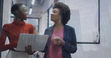 Animation of financial data processing over diverse businesswomen in office. Global business, finance, computing and data processing concept digitally generated video.