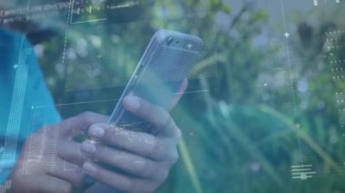 Animation of financial data processing over boy using smartphone. Global business, finances, computing and data processing concept digitally generated video.