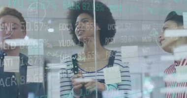Animation of financial data processing over diverse colleagues discussing over glass board at office. Global economy and business technology concept