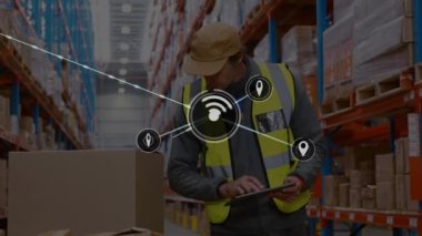 Animation of connected gps and wifi icons over caucasian man with tablet examining box in warehouse. Digital composite, network, location, inspection, technology, logistics, shipping concept.