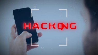 Animation of scope scanning over hacking text banner over rear view of a man using smartphone. Cyber security and business technology concept