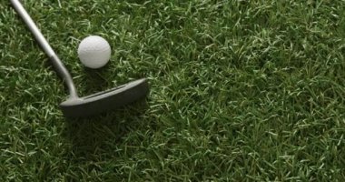 Close up of golf club and ball on grass, copy space, slow motion. Golf, sport and hobby concept.