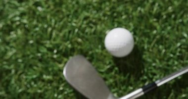 Close up of golf club and ball on grass, copy space, slow motion. Golf, sport and hobby concept.