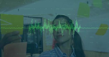 Animation of data processing over caucasian woman writing on memo notes at office. Business technology concept