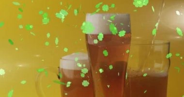 Animation of st patrick's day green shamrock falling over beer glasses. St patrick's day, irish tradition and celebration concept digitally generated video