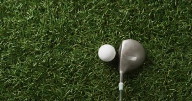 Close up of golf club and ball on grass, copy space, slow motion. Golf, sport and hobby concept.