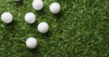 Close up of golf balls on grass, copy space, slow motion. Golf, sport and hobby concept.