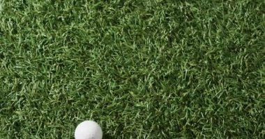 Close up of golf ball on grass, copy space, slow motion. Golf, sport and hobby concept.