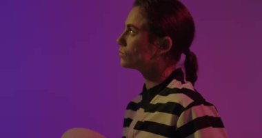 Animation of neon circles over female rugby player on neon background. Sports and communication concept digitally generated video.