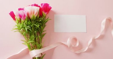 Video of pink and white flowers and card with copy space on pink background. Mothers day, nature and spring concept.