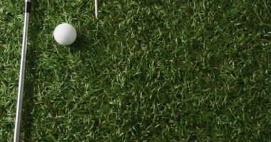 Close up of golf club and ball on grass, copy space, slow motion. Golf, sport and hobby concept.