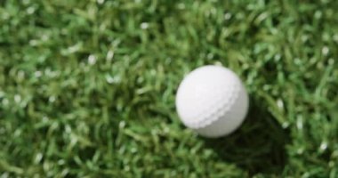 Close up of golf ball on grass, copy space, slow motion. Golf, sport and hobby concept.