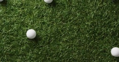 Close up of golf balls on grass, copy space, slow motion. Golf, sport and hobby concept.