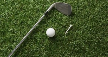 Close up of golf club and ball on grass, copy space, slow motion. Golf, sport and hobby concept.