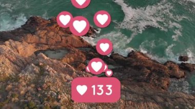 Animation of heart social media people icon and numbers over landscape. Global social media, business, finances, computing and data processing concept digitally generated video